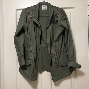 Women’s green utility jacket with flower embellishments